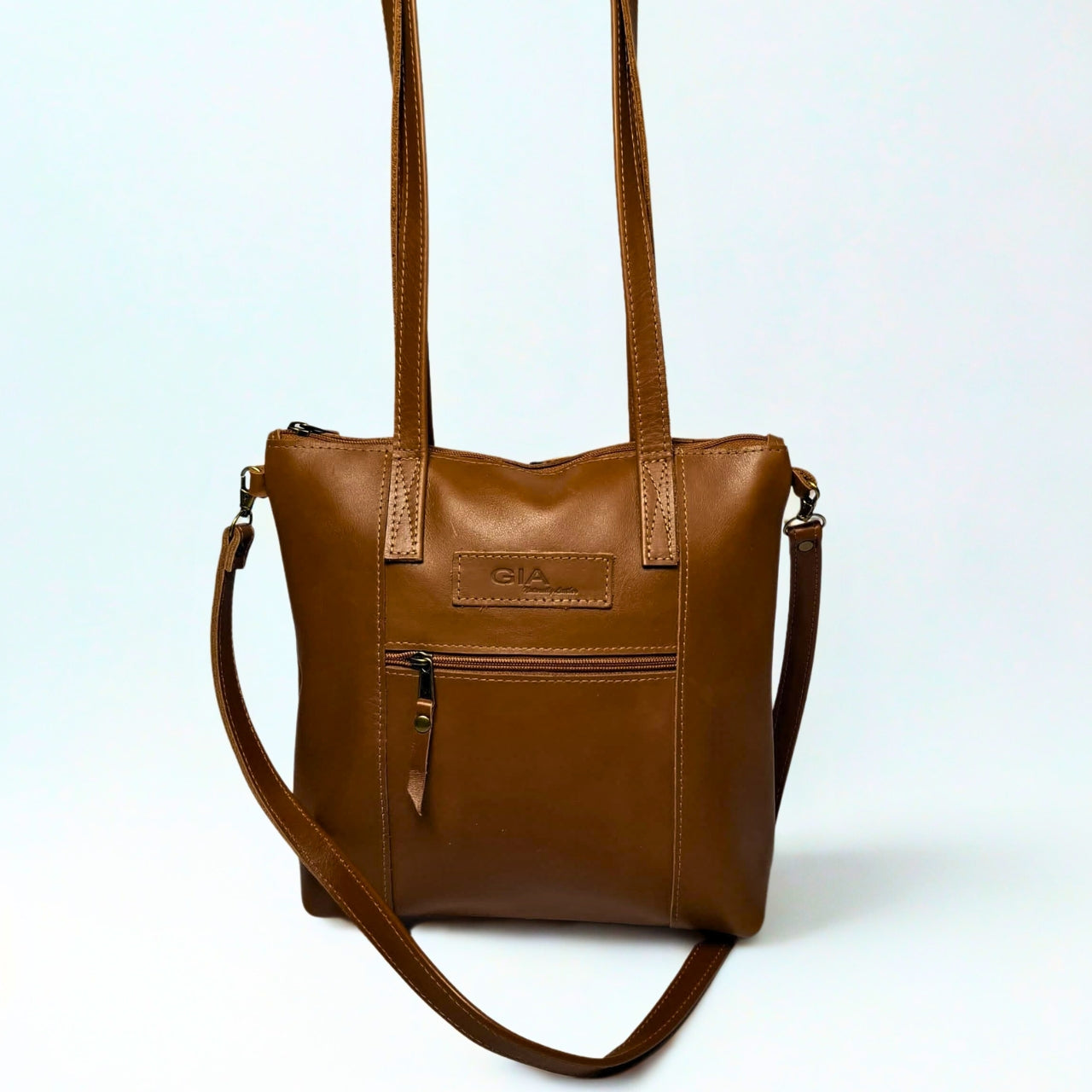 Gia Camera Bag in Texas Toffee leather – compact crossbody with zip closure, rear magnetic pocket, adjustable strap, and embossed GIA logo patch 1