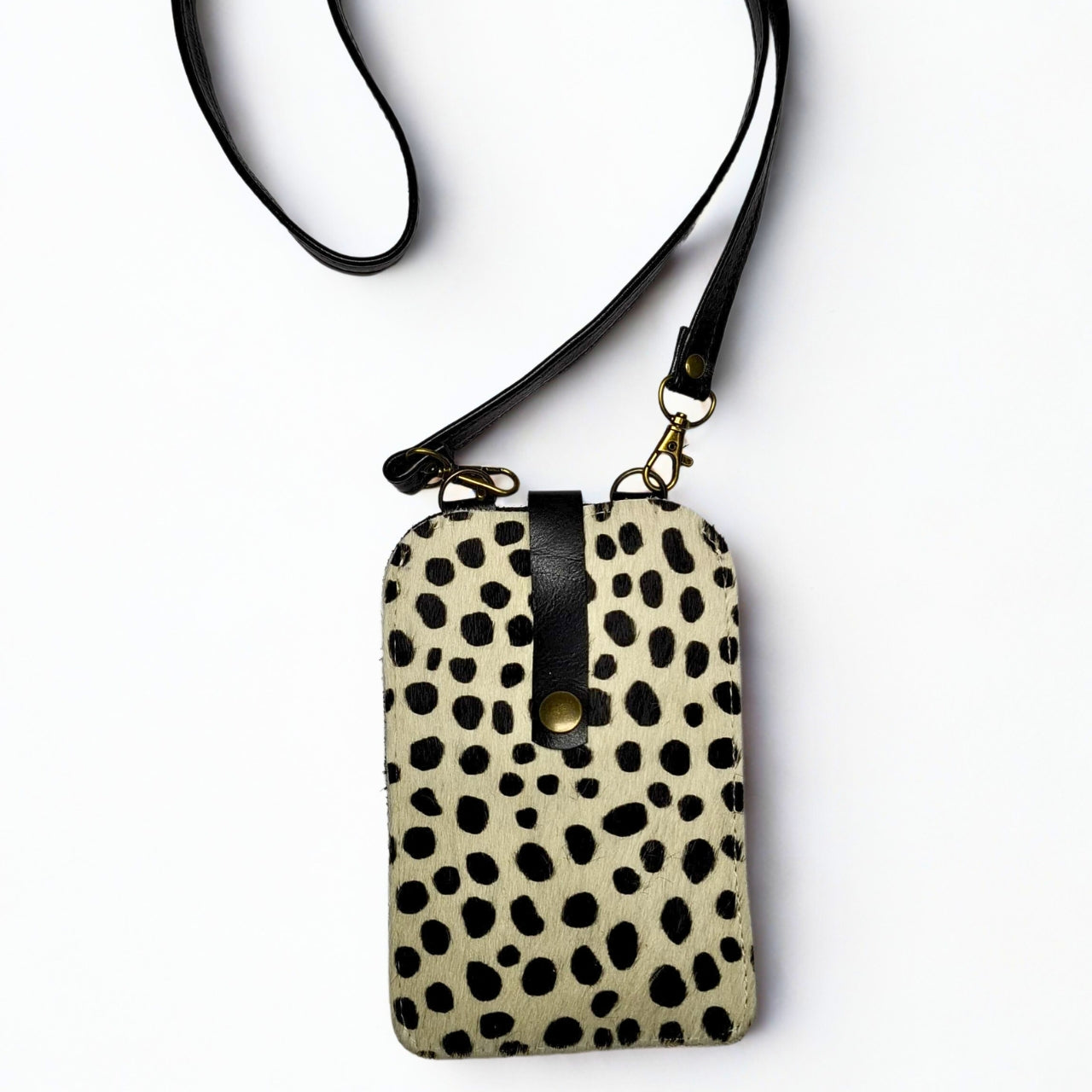 Gia Cell Bag in black and white cheetah print – hair-on-hide leather, compact hands-free design with gold hardware and detachable strap, fits most smartphones. 1