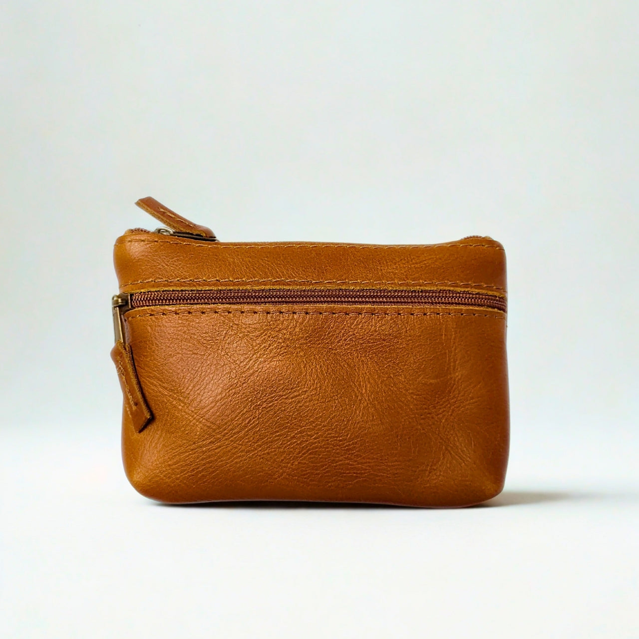 Gia Tan Double Zip Lipstick Purse, crafted from genuine leather. Features two secure zippered compartments for easy organization, perfect for lipstick, coins, and small essentials.
2