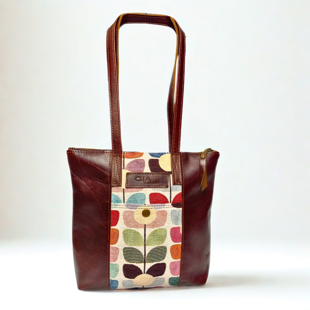 Gia dark brown leather tote with vibrant tulip fabric panel, front zip pocket, and dual handles.