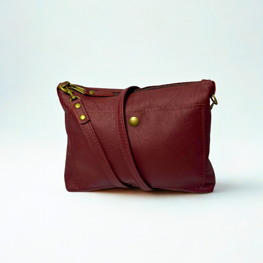 Gia dark red crossbody bag in genuine leather with adjustable strap, antique brass hardware, and embossed logo – compact designer handbag for everyday wear and evening outings.