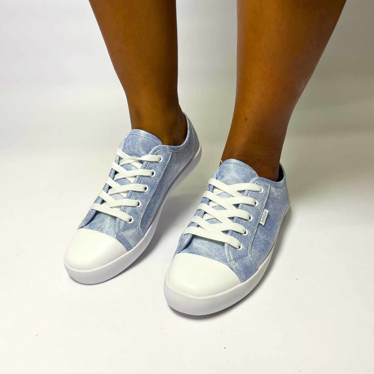 Holster Cleo Light Denim Shimmer Sneaker – Vegan-friendly, cruelty-free lace-up sneaker with a fabric shimmer PU upper and white PU toe cap. Features soft cotton lining, padded PU foam insole, and non-slip rubber outsole. Designed with antibacterial and anti-mould properties for lasting freshness. 1