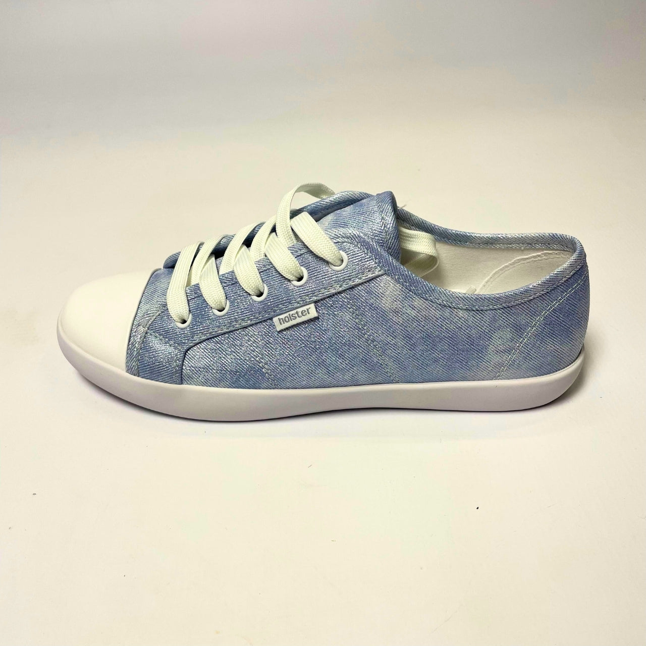 Holster Cleo Light Denim Shimmer Sneaker – Vegan-friendly, cruelty-free lace-up sneaker with a fabric shimmer PU upper and white PU toe cap. Features soft cotton lining, padded PU foam insole, and non-slip rubber outsole. Designed with antibacterial and anti-mould properties for lasting freshness. 3