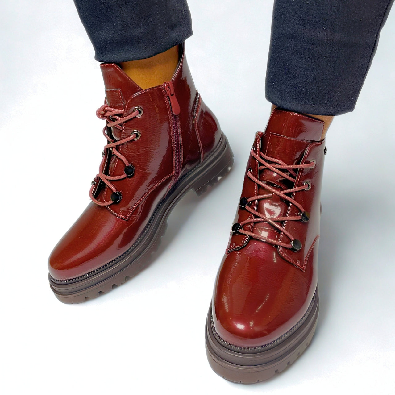 Burgundy faux leather chunky lace-up boots with gold eyelets, side zip, and thick treaded sole for bold street style.