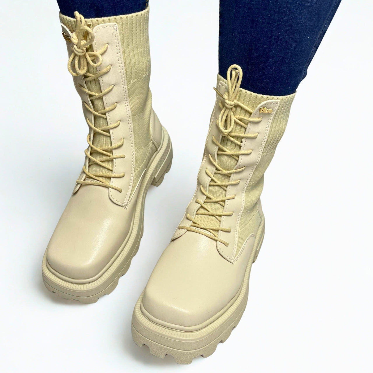 Plum beige combat-style boot with ribbed knit shaft, chunky lug sole, and lace-up front.