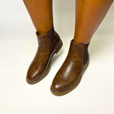 Butterfly Celeste 4 Chocolate Ankle Boot, a stylish faux leather slip-on boot with a round toe, elastic gusset, and contrast back heel detail. Features a comfort sock for all-day wear and a 2.5 cm heel. Perfect for casual and chic styling. 1