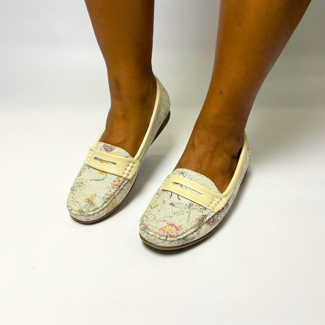 Cushion Walk Beige Floral Moccasin – soft-textured slip-on shoe featuring a pastel floral print design. Includes a comfort inner sole for all-day wear and a flexible, lightweight sole for extra comfort. Perfect for casual outings, work, and travel. 1