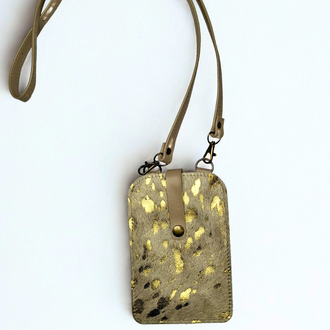 Gia Cell Bag in gold and taupe cheetah print – hair-on-hide leather, compact hands-free design with gold hardware and detachable strap, fits most smartphones. 
1