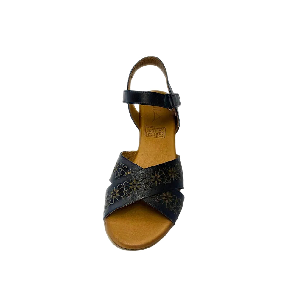 Gia black leather wedge sandals with laser-cut floral cross-over straps, cushioned insole, ankle strap, and natural wood finish heel – elegant women’s summer wedges for comfort and style.
