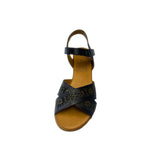 Gia black leather wedge sandals with laser-cut floral cross-over straps, cushioned insole, ankle strap, and natural wood finish heel – elegant women’s summer wedges for comfort and style.
