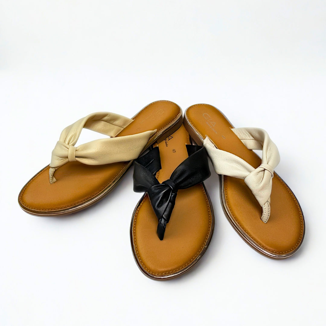 Gia black leather knot sandals with cushioned insole, slip-on design, and knotted strap detail – chic women’s summer footwear for casual wear, holidays, and resort style.