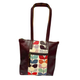 Gia dark brown leather tote with vibrant tulip fabric panel, front zip pocket, and dual handles.