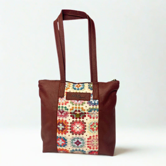 Gia dark red leather tote bag with woven tapestry panel, dual shoulder straps, antique brass hardware, and embossed logo – spacious crochet-inspired handbag for work, travel, and everyday wear.