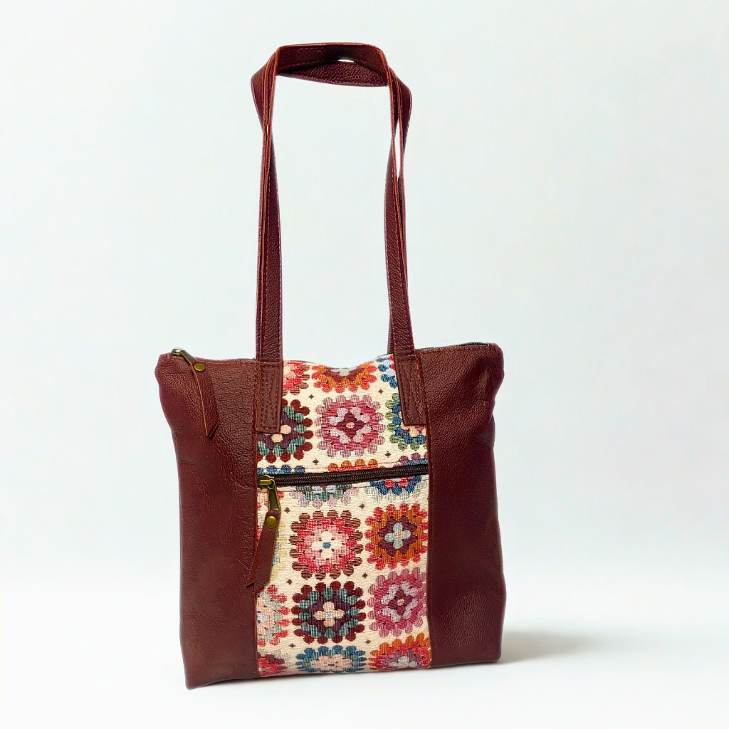 Gia dark red leather tote bag with woven tapestry panel, dual shoulder straps, antique brass hardware, and embossed logo – spacious crochet-inspired handbag for work, travel, and everyday wear.