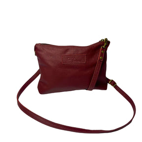Gia dark red crossbody bag in genuine leather with adjustable strap, antique brass hardware, and embossed logo – compact designer handbag for everyday wear and evening outings.