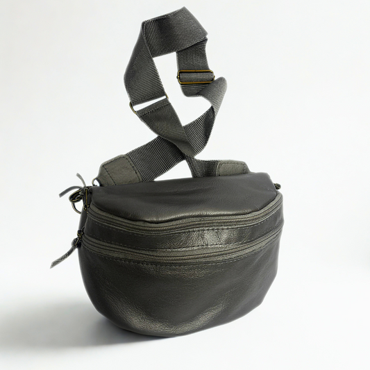 Gia pewter leather moon bag with wide adjustable strap, metallic finish, antique brass hardware, and embossed logo – versatile crossbody or waist bag for modern street style and everyday use.