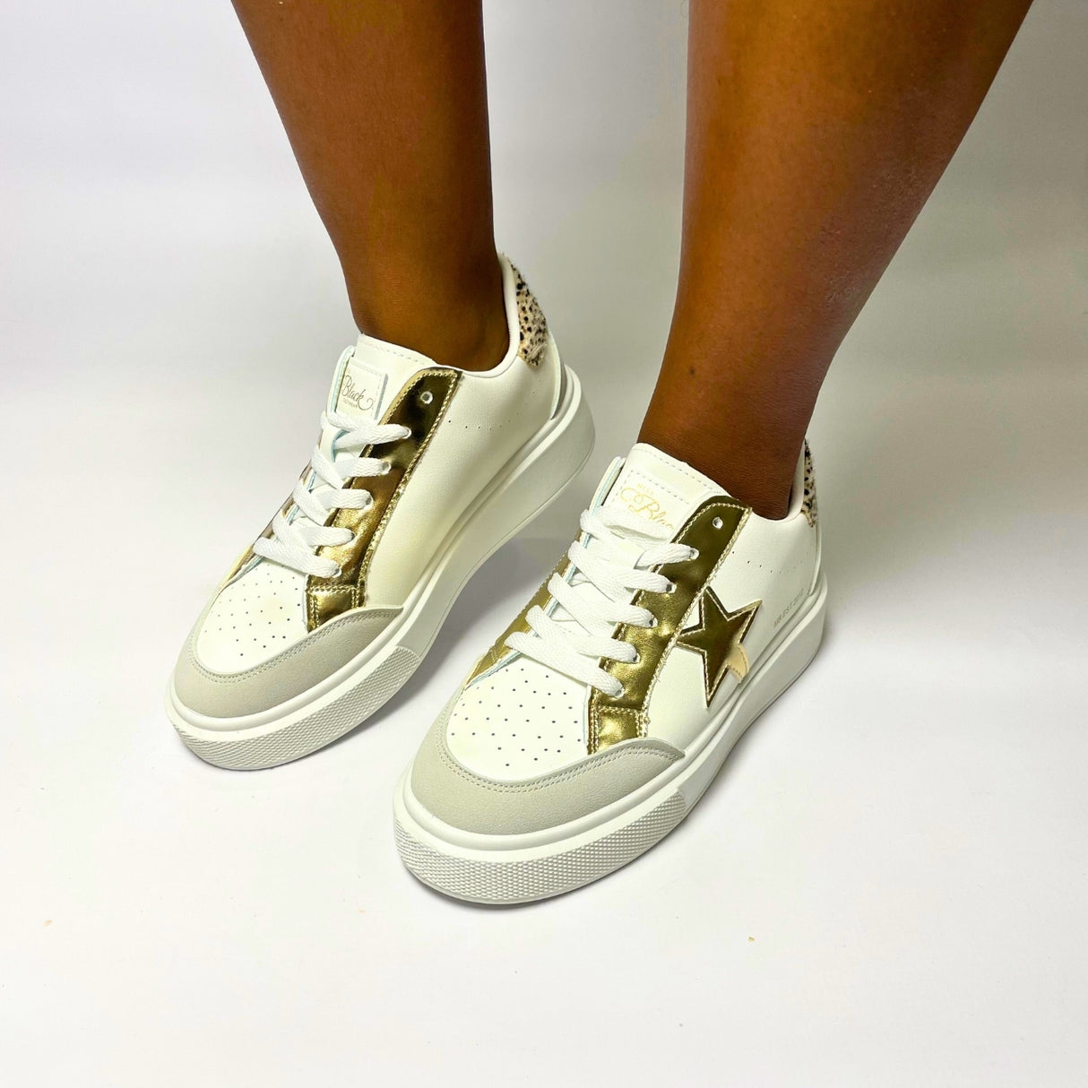 Miss Black Twinkle 1 White/Gold Lace-Up Sneaker – Faux leather upper with star detail and mixed materials. Featuring a round toe, lace-up design, and thick bottom for added comfort. Heel height: 4 cm. Perfect for casual wear and adding a touch of sparkle to your look. 1