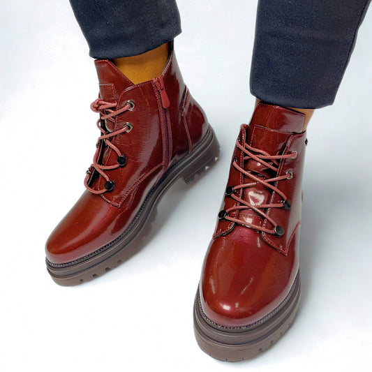 Burgundy faux leather chunky lace-up boots with gold eyelets, side zip, and thick treaded sole for bold street style.
